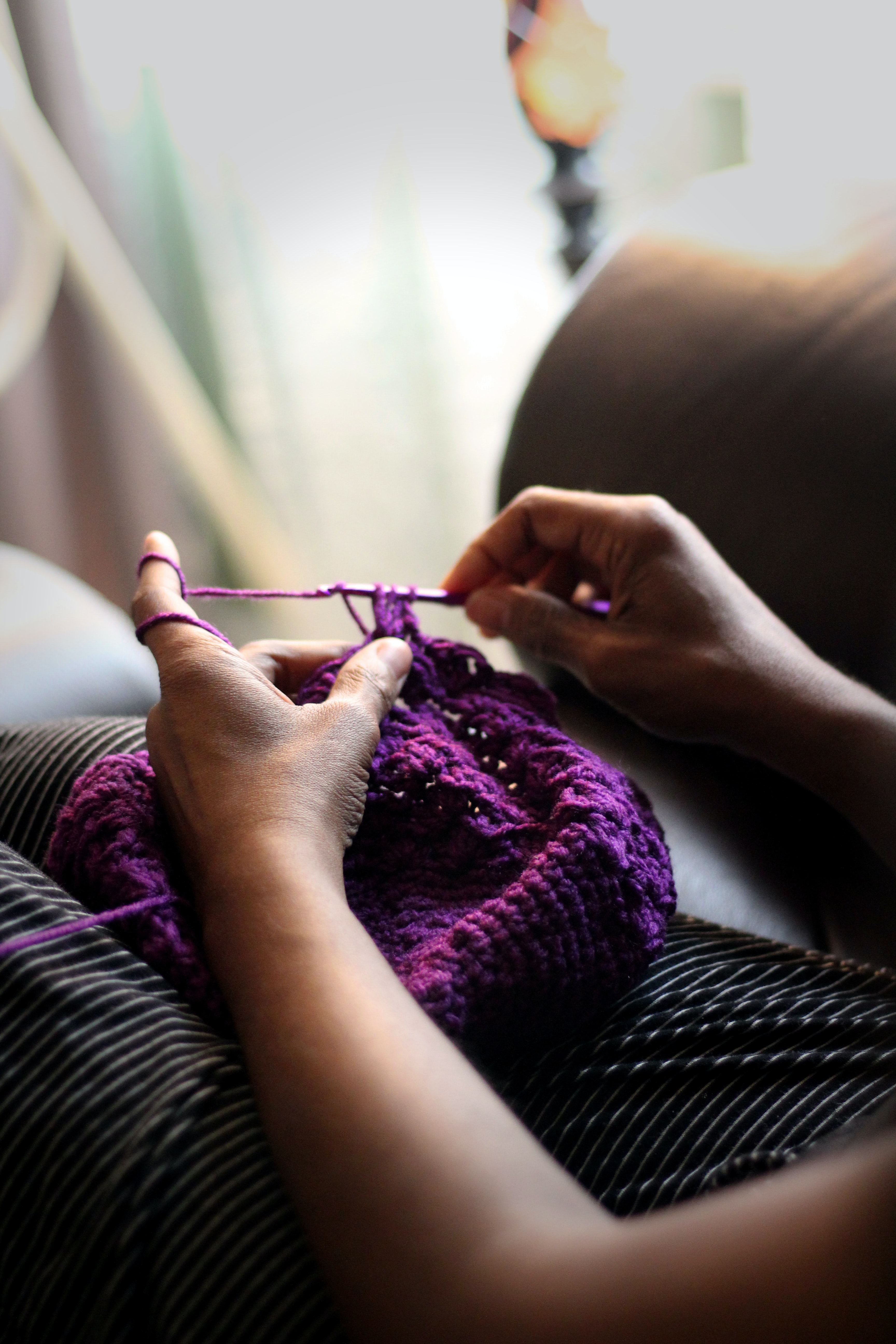 Person crocheting with purple yarn