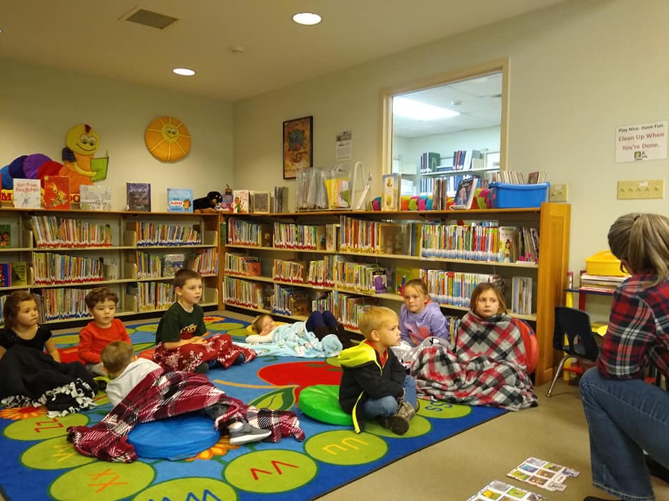 Group of children in library on alphabet run listening to stories