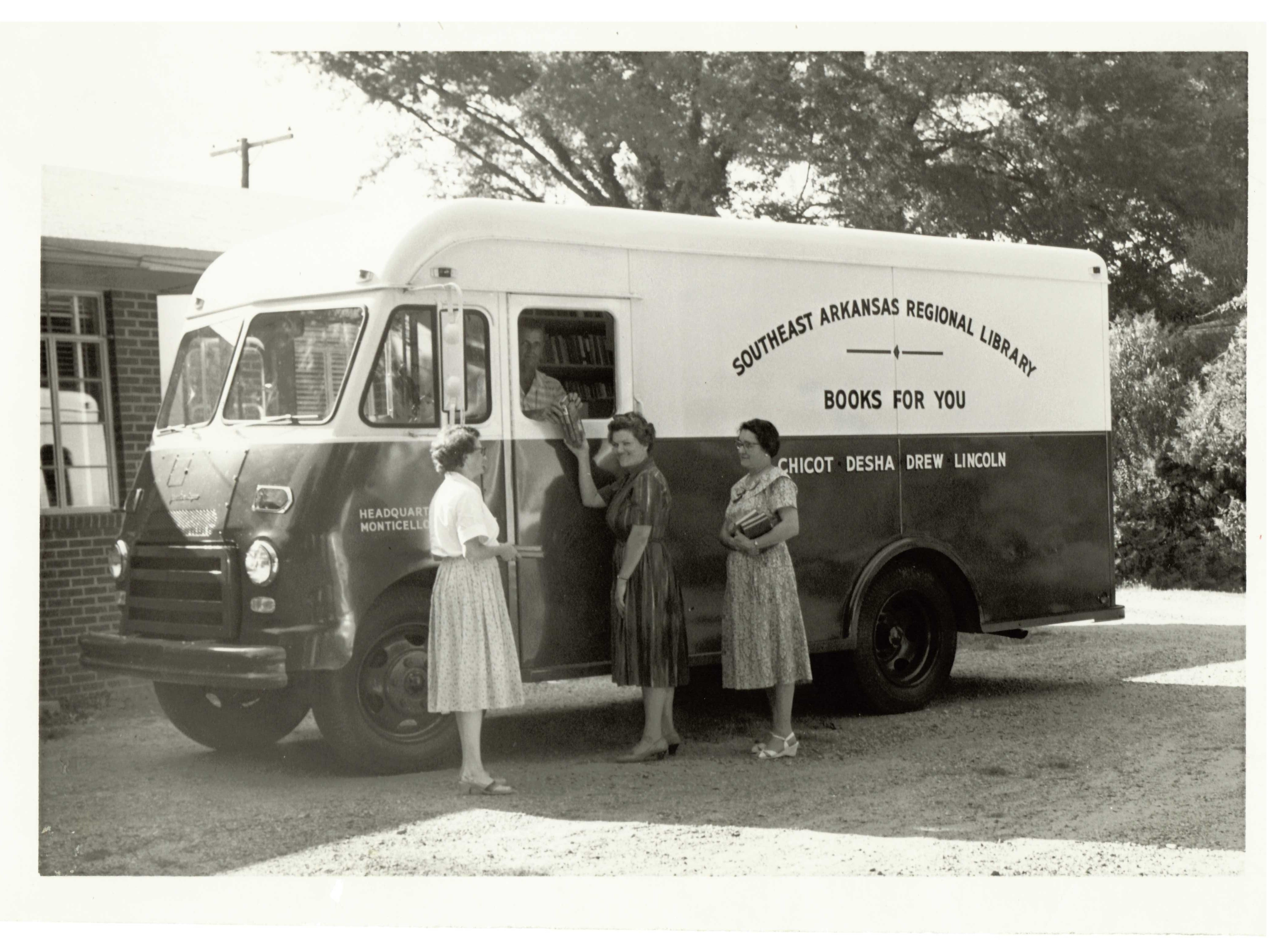 Black and white photo of people at a historic library bookmobile