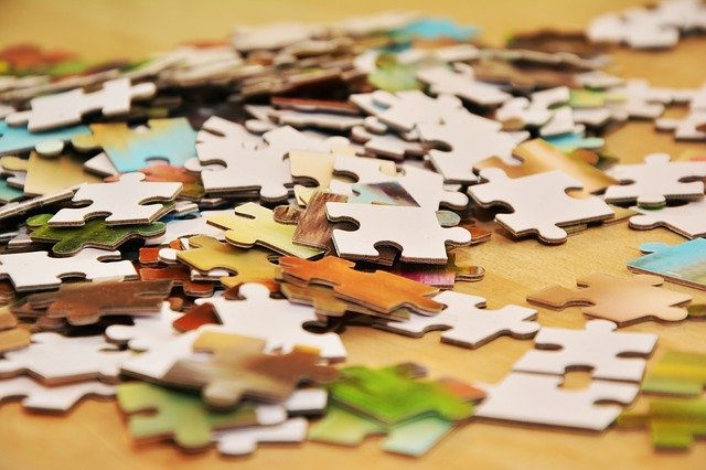 Jigsaw puzzle pieces scattered on table
