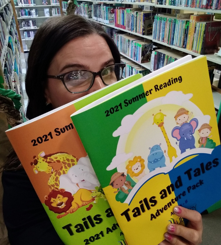 image of librarian holding workbooks for kids