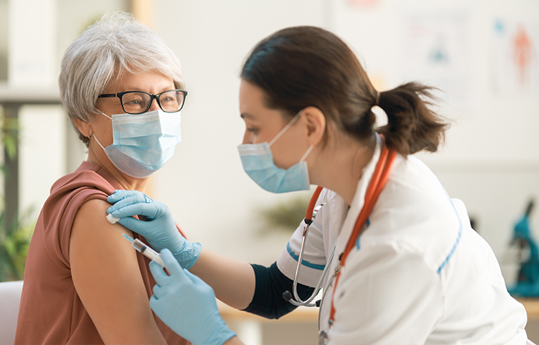 Adult receiving vaccine in arm by health care provider. 